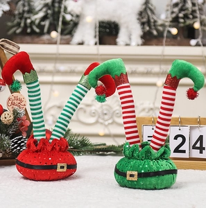 Detailed view of striped Christmas elf legs with sequins on a fuzzy white surface