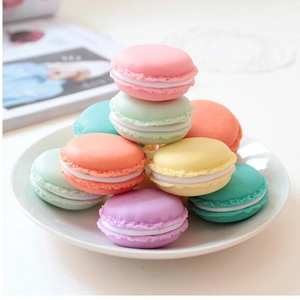 Mini macaron style jewelry storage box in assorted pastel colors on a decorative plate