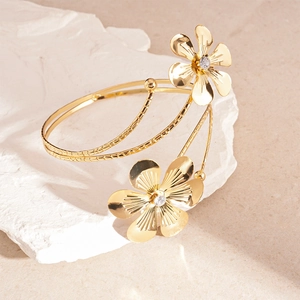 Detailed macro shot of a golden floral arm cuff with sparkling rhinestones on stone
