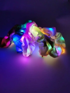 Detail of LED glowing satin scrunchies with vibrant multi-color lights in dark setting