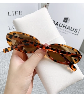 Detail of trendy cat-eye leopard print sunglasses with brown lenses and carrying case