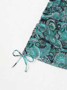 Detail view of emerald green paisley print fabric with side drawstring and ruched texture