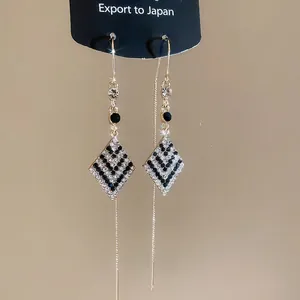 Élégantes boucles d'oreilles pendantes dorées avec losanges sertis de strass bicolores