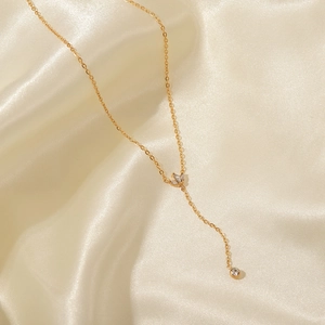 Détail du collier en acier titane plaqué or 18K avec pendentif couronne en zircon