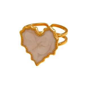 Macro detail of a golden vintage heart ring featuring an artistic embossed cameo inlay