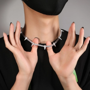 Detail of silver spiked Cuban chain necklace with zircon inlay worn by a male model