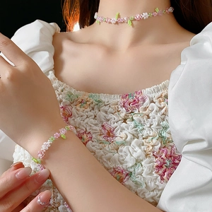 Close-up of beaded flower necklace and bracelet set worn on neck and wrist