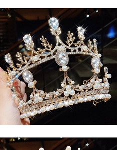 Close-up of golden crown headband with white pearls and sparkling crystal rhinestones