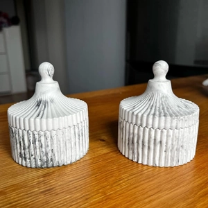 Detailed view of striped resin storage jars with marble texture and round lid knobs
