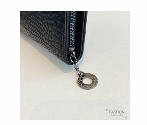 Close-up of high-quality silver metal zipper on black crocodile texture leather wallet