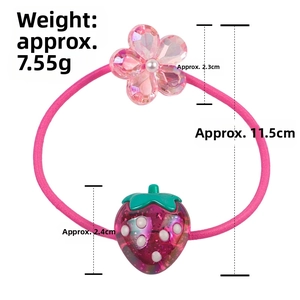 Detail of pink elastic hair tie with glitter strawberry and floral charms
