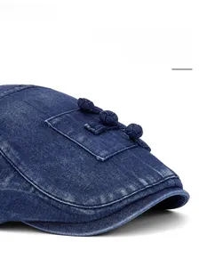 Détail de la casquette plate en jean bleu avec visière réglable et boutons vintage