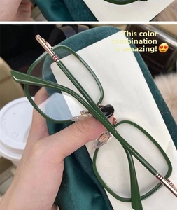 Detail of dark green full-frame glasses with rose gold metal temples and striped tips