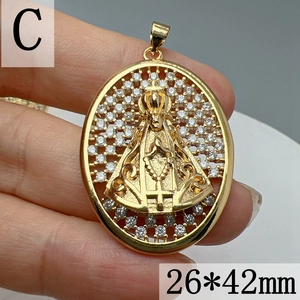 Detalle de un colgante de la Virgen María dorado con circonitas, tamaño 26x42mm, en mano