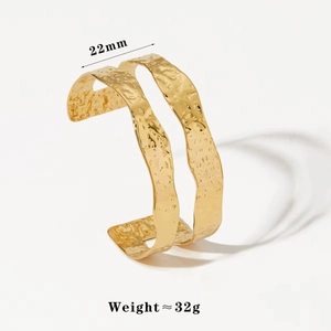 Detailed macro view of 22mm wide gold-plated stainless steel cuff with hammered texture