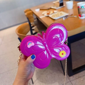 Detailed close-up of a butterfly-shaped purple jelly bag with a gold chain strap