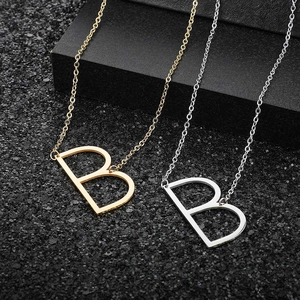 Detailed view of large hollow letter B pendants in gold and silver stainless steel