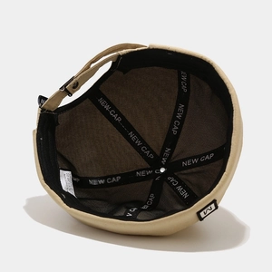 Beige cotton brimless docker hat with adjustable strap and inner brand tape detail