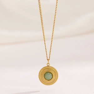 Vintage gold plated necklace featuring a round green aventurine pendant with sunburst detail