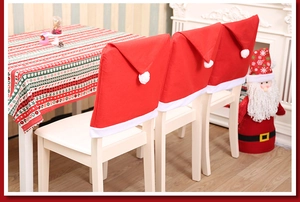 Close-up of red non-woven Christmas hat chair covers for festive dining room decoration