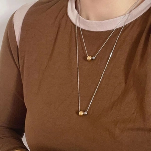 Minimalist 18k gold and silver beaded double layer necklace shown on a model