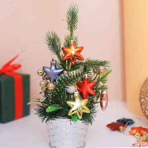 Miniature Christmas tree with colorful star ornaments and golden berries in a woven base