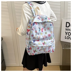 Dettaglio zaino in tela celeste con motivi colorati di farfalle e fiori per studentesse