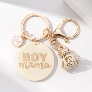 Handmade BOY mama keychain with beige faux leather charm and pink tassel on marble background