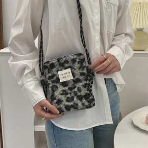 Detail view of plush leopard print mini bag showing fuzzy texture and logo patch