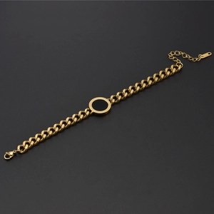 Macro shot of gold Cuban chain bracelet with black circular Roman numeral engraving