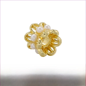Vue détaillée d'une perle fleur en laiton doré 4mm avec de petites perles blanches