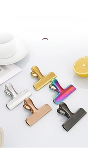 Macro detail of brushed stainless steel clips in gold, rose gold, and black finishes
