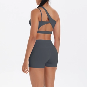 Detail of dark gray one-shoulder yoga top with back cutout and high-waist sports shorts