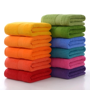 Absorbent pure cotton bath towels stacked in vibrant colors like orange, red and blue