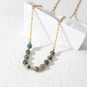 18K gold plated beaded necklace with colorful stones on a white stone background