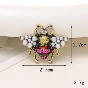 Dettaglio accessorio ape con perle bianche e cristalli rossi, misura 2,7 x 2,2 cm