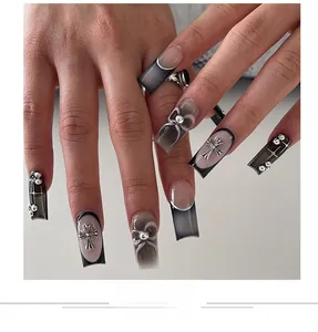 Detail of grey cat-eye nails with metallic crosses and pearl bows in Y2K gothic style