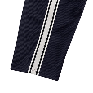 Detail of navy corduroy pants featuring side striped webbing and textured ribbed fabric