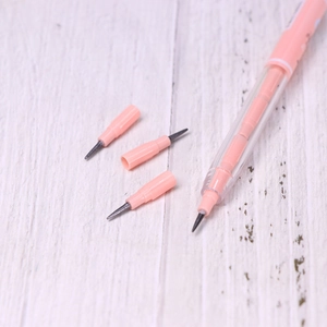 Close-up of pink non-sharpening stacking pencil with replacement tips on white wood