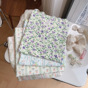 Diverse borse shopping in cotone con stampe floreali blu e viola su un tavolo bianco