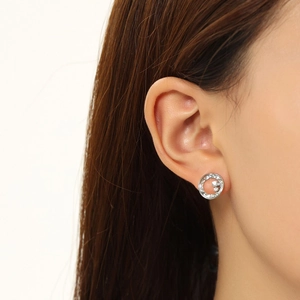Macro detail of silver geometric hoop earrings with sparkling diamonds on a model