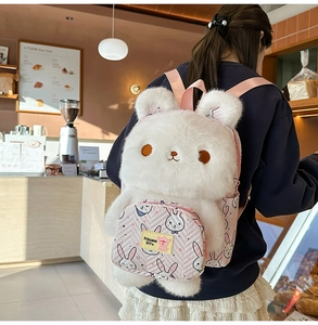 Detail of white plush bunny backpack featuring pink quilted front pocket and soft straps