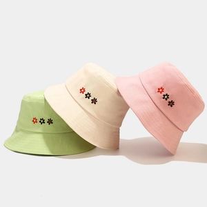 Three cotton bucket hats with flower embroidery in green, beige and pink colors