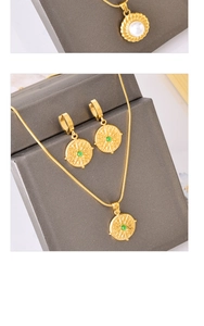 Detail view of gold jewelry set featuring green agate pendants and pearl necklace accents