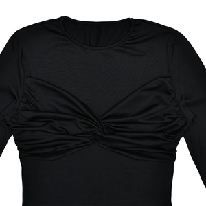 Détail du design de nœud frontal chic et du tissu en maille sur une robe noire à manches longues
