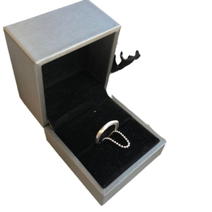 Minimalist silver ring with fine bead chain detail in a grey velvet jewelry gift box