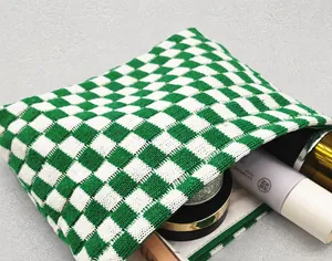 Close-up of green and white checkered knit pouch showing texture and internal capacity