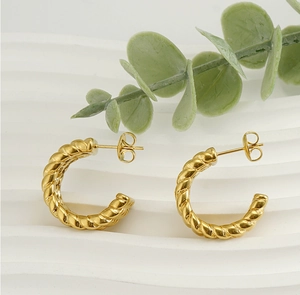 Close-up of gold twist texture C-shaped hoop earrings with butterfly back on white display