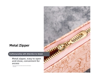 Detail of pink floral embossed leather wallet featuring a durable golden metal zipper
