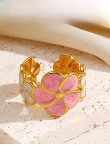 Close-up of pink and white enamel flower ring with golden petals and open band design